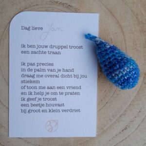 blauwe troostdruppel met kaartje tekst op achterkant